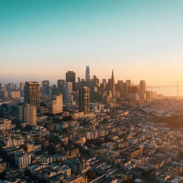 的 skyline of San Francisco is seen from the air in a golden light.